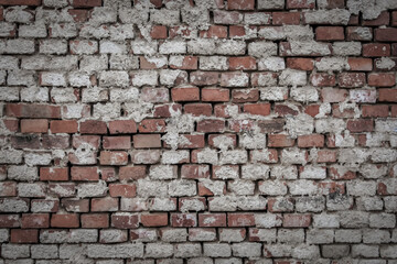 Obraz premium Brick wall with remnants of plaster and cement rendering, color graded