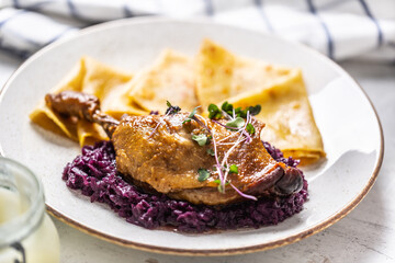 Portion of duck leg with red cabbage and potato pancakes, a traditional autumn dish in Eastern Europe