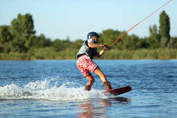 Fototapeta premium Teenage boy wakeboarding on river. Extreme water sport