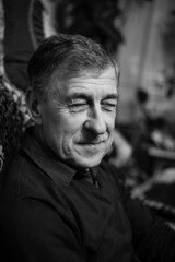 Portrait of a granddad on the dark background, black and white photo