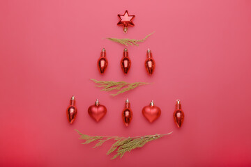 Christmas composition. Christmas red decorations, fir tree branches on red background. Flat lay, top view, copy space
