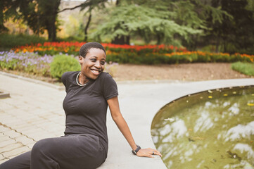 Attractive happy smiling young natural beauty short haired African woman wearing total black...
