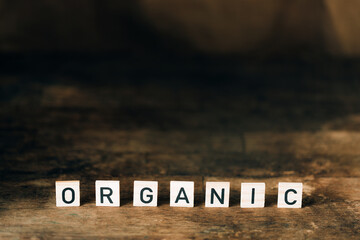 Dark wooden background with wooden letters. Organic food concept.
