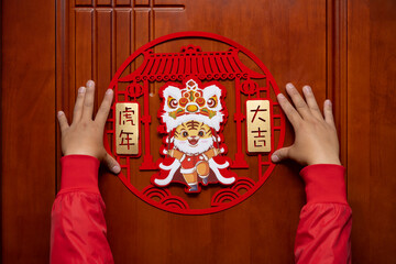 sticking a Chinese New Year of tiger 2022 mascot to the door translation of the Chinese is good...