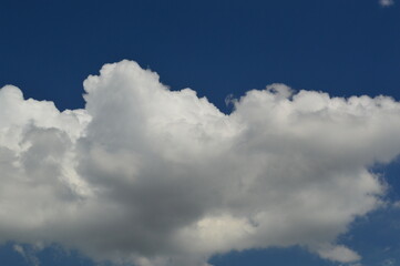 Naklejka na ściany i meble Large white clouds on a blue sky background