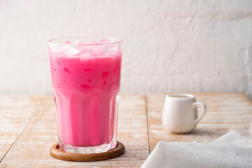 Thai style iced pink milk.Cold sweet drink Red Grenadien Sugar Syrup mix with milk and iced cube in glass