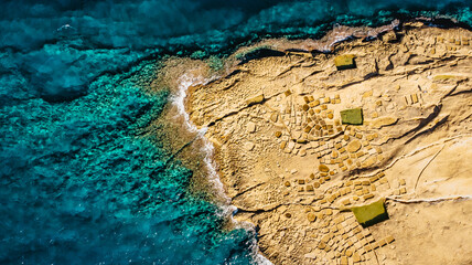 Aerial view of Xwejni Salt Pans,Xlendi Cliffs on Gozo island,Malta.Amazing natural creations from limestone.Traditional Sea-Salt production.Mediterranean summer vacation.Picturesque scenery