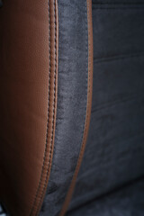 skin texture, brown leather with black seams. armchair made of leather and black suede. new car...