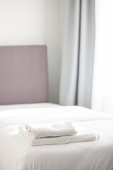 Fototapeta na wymiar White clean towels stacked on the hotel bed. High quality photo