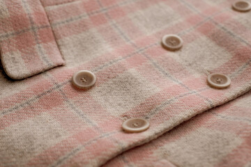 Buttons placed on a fabric plaid wool jacket. Vintage syle