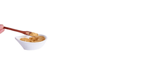 Peruvian maca powder with rustic wooden spoon on a white background. selective focus