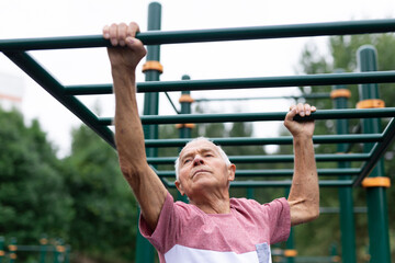 Fototapeta premium Old climbing on horizontal ladder outdoors