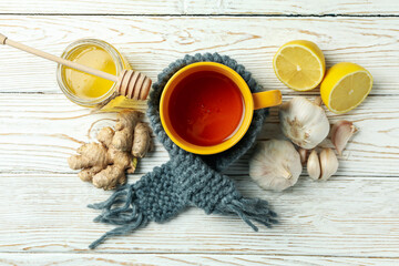 Concept of treatment colds with honey and garlic on white wooden background