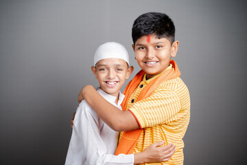 Happy Hindu Muslim Children Hugging Each Other and looking camera with smile - Concept of friendship, togetherness, unity in diversity and freedom of religion
