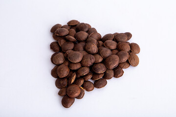 Naklejka premium Sacha Inchi roasted seed nuts, selective focus on front seeds, on white background. heart shape
