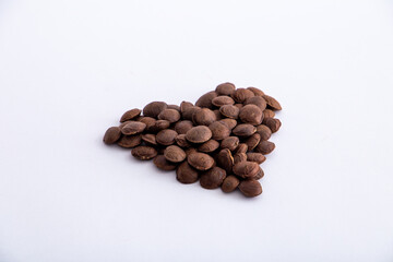 Sacha Inchi roasted seed nuts, selective focus on front seeds, on white background. heart shape