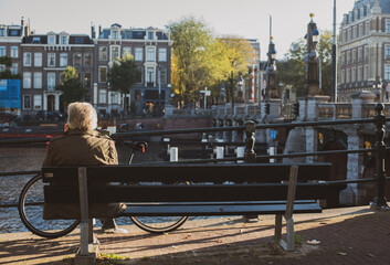 men sitting on the bench near river Amstel