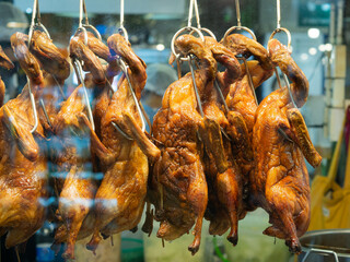 Roast ducks are displayed in a glass cabinet