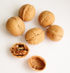 Walnuts. Shelled and unshelled walnuts isolated on white background, on table. Macro, close up, top view.