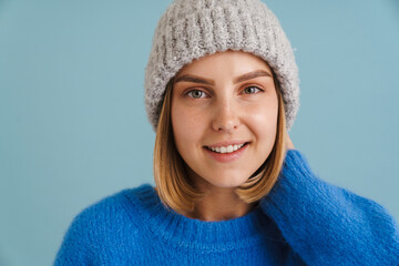 Young blonde woman wearing knit hat smiling at camera