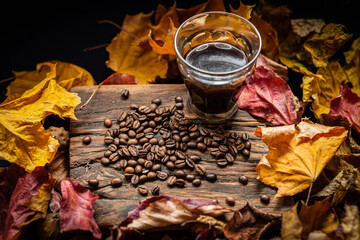 autumn leaves with coffee beans on rustic wood
