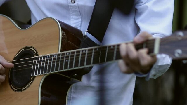 The musician plays the guitar during a live performance. close-up of hands