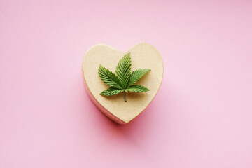Cannabis leaf on heart-shaped gift box. Valentine's day sale. Top view