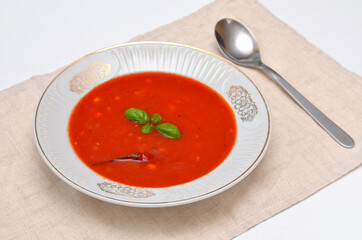 tomato soup with chili and corn in a white plate