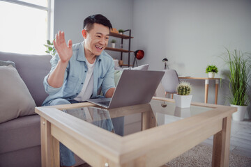 Photo of business man chinese man sit couch prepare remote video call zoom deal wear casual shirt...