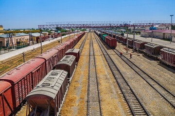 Panorama of railway tracks with trains. The station is visible on the right. Shot in Termez, Uzbekistan