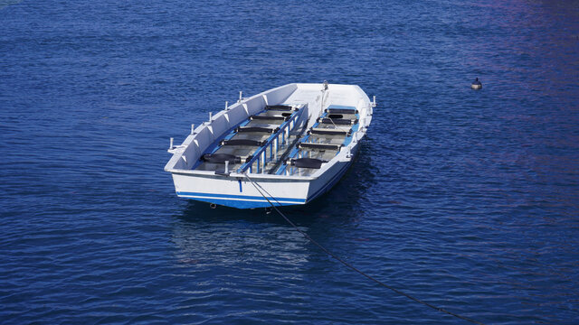 empty multi-seat boat sways on the waves, photo picture