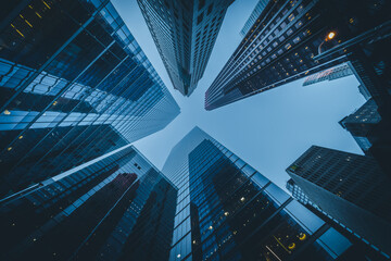 Business and finance concept, looking up at high rise office buildings at dusk in the financial...