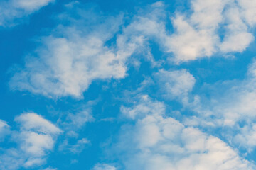 Summer white cumulus clouds against the blue sky. Bright sunny day.