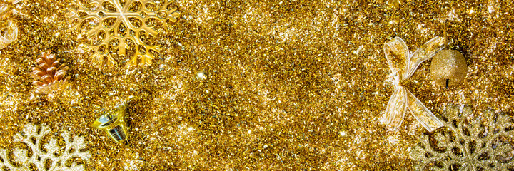 Christmas background with gifts, gold ribbon and gold Christmas decorations, glitter. Christmas background, top view. Copy space. Banner.