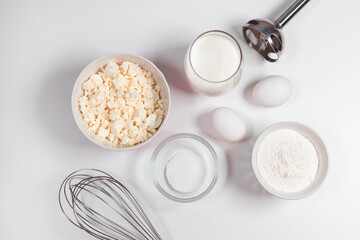 Baking utensils and cooking ingredients for a tarts, cookies, dough and pastry. Flat lay with eggs, flour, sugar, cottage cheese