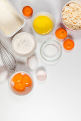 Baking utensils and cooking ingredients for a tarts, cookies, dough and pastry. Flat lay with eggs, flour, sugar, cottage cheese