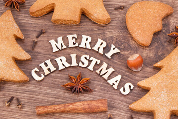 Inscription Merry Christmas with homemade gingerbreads and cookies for festive time