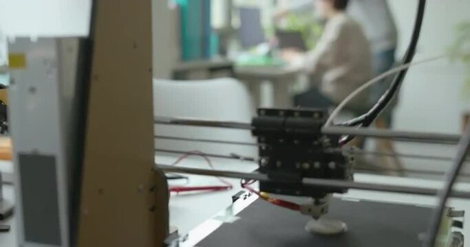 3D printer printing a prototype and engineering students