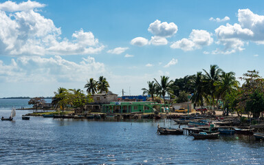 Obraz premium A charming coastal village in Cuba with traditional buildings along the water, offering a glimpse of relaxed island life