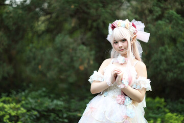 Obraz na płótnie Canvas Beautiful young woman with white lolita dress with flowers garden Japanese fashion