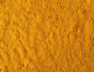 Turmeric powder pile background and texture, top view
