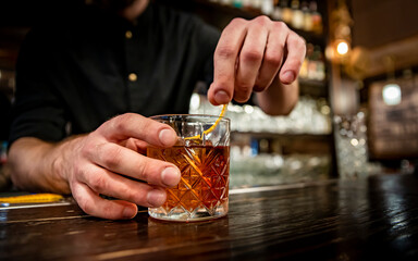 man hand bartender making negroni cocktail in bar