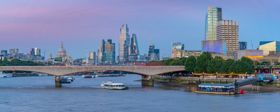 View of Waterloo Bridge over the River Thames, St. Paul's Cathedral and The City of London skyline at dusk, London