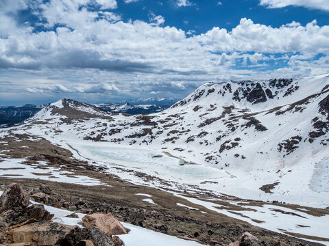 Snow-capped mountains and a frozen lake near Beartooth Pass
