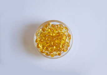 White background from tablets of gelatinous golden yellow capsules, vitamin D3. Beautiful colored golden vitamin D3 tablets, background, nutrition, nutritional supplements. A bunch of vitamin D3.