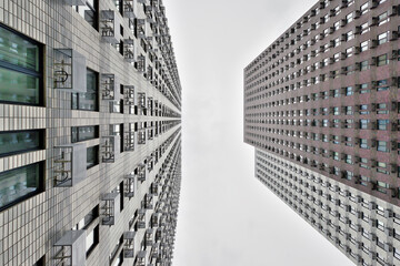 Fototapeta na wymiar Modern high-rise apartment buildings. Gray houses against a grey sky. Bottom view