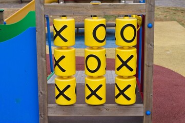 A plastic and wooden tic-tac-toe game in a children's playground in a public park (Umbria, Italy, Europe) - 469523983