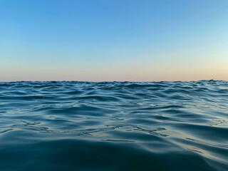 Obraz premium Blue sea at sunset, horizon, close-up, background
