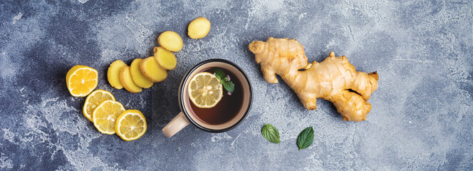 Cup of hot Ginger tea with lemon and honey on dark gray background. Top view. Copy space