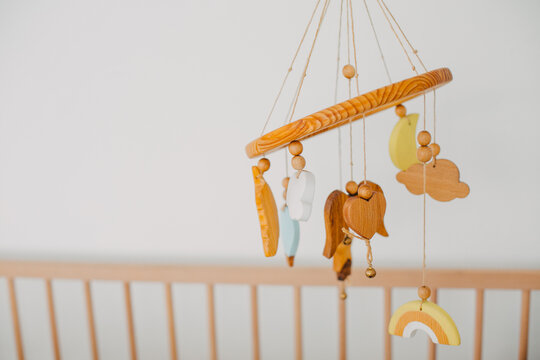 wooden baby toys hang over the crib.